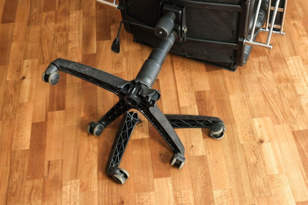 A luggage cart on the floor with a suitcase resting on top ready for transport
