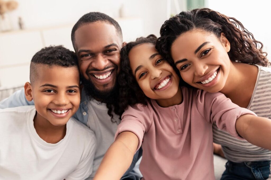 A happy family smiling and posing for a selfie together - Life Insurance for a stay-at-home parent