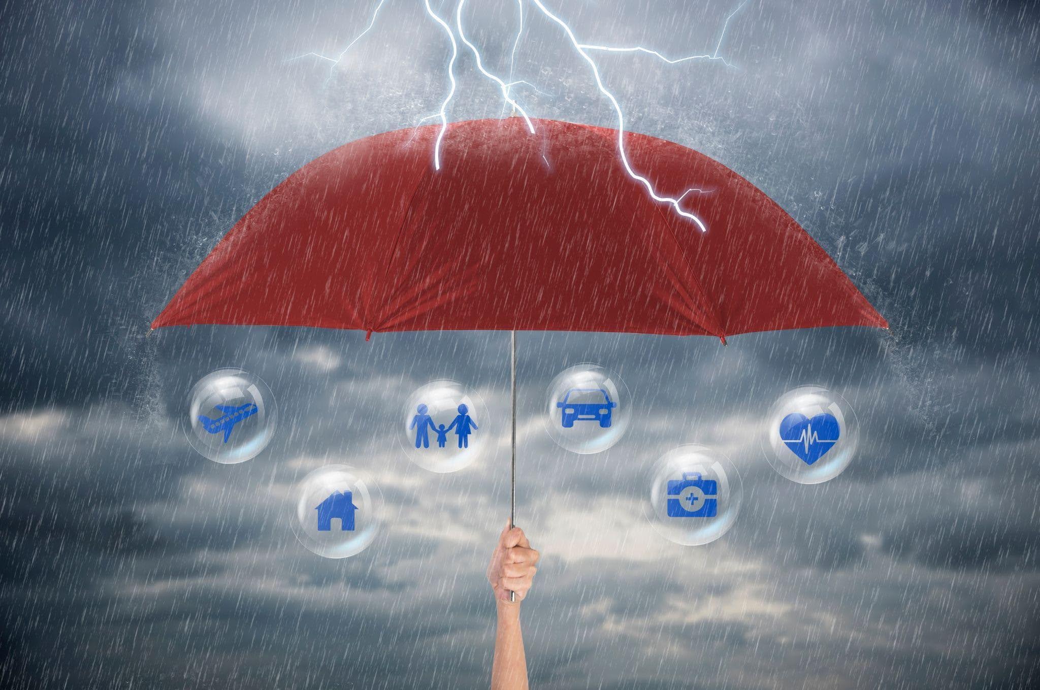 An umbrella covered with various insurance related icons symbolizing comprehensive coverage and protection